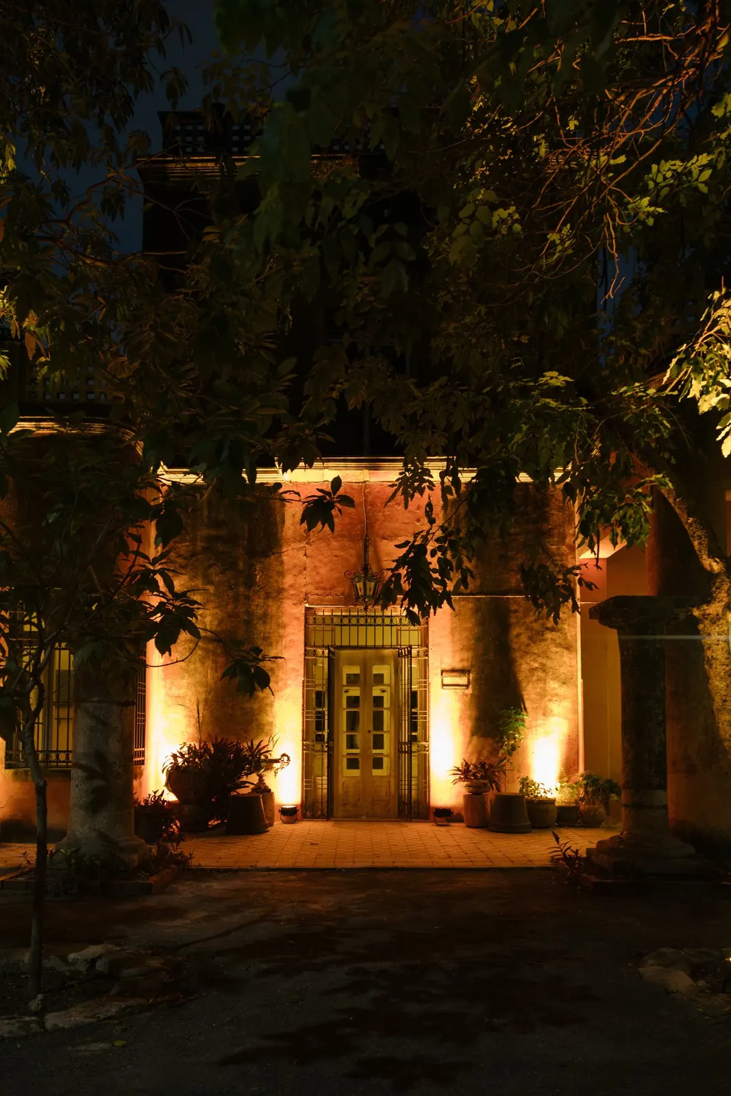 La fachada de la casa desde el jardín, de noche