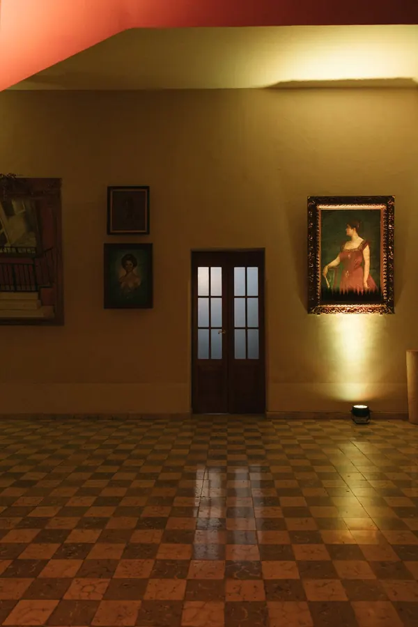 Un salón con sus cuadros, de noche